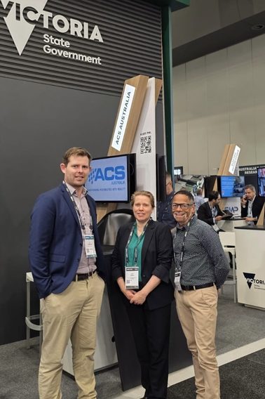 Joe Rokebrand and Andre Duarte from ACS Australia with Erica Dubern from Global Victoria at Land Forces 2026